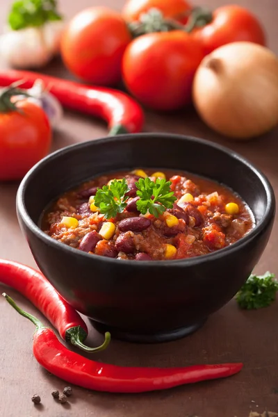 Mexikanska chili con carne i svart skål med ingredienser — Stockfoto