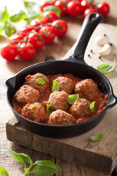 Meatballs with tomato sauce in black pan — Stock Photo, Image