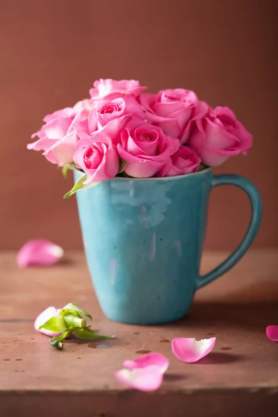 Hermoso ramo de rosas rosadas en taza — Foto de Stock