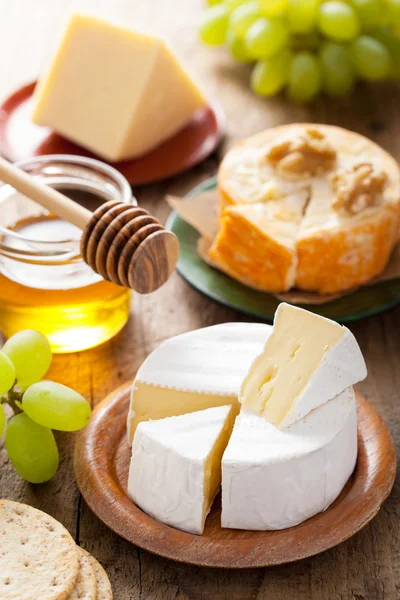 Cheese plate with camembert, cheddar, grapes and honey — Stock Photo, Image
