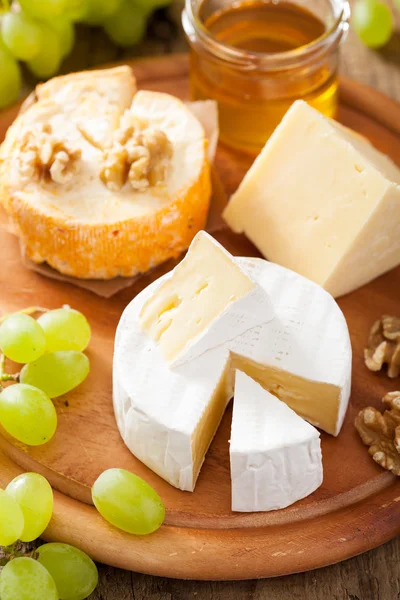 カマンベール、チェダー チーズ、ブドウ、蜂蜜とチーズの盛り合わせ — ストック写真