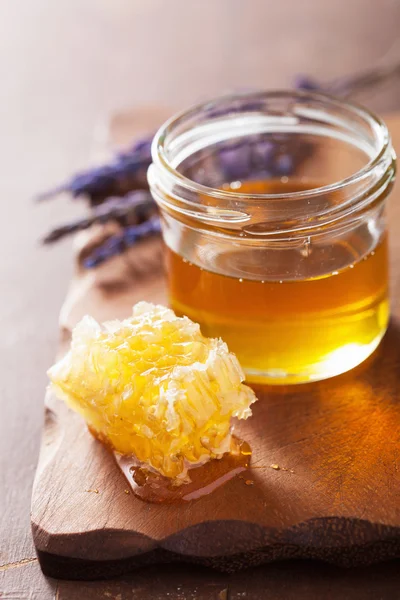 Favo de mel e mel em jarra no fundo de madeira — Fotografia de Stock