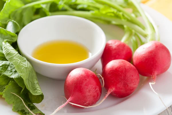 Fresh radish and olive oil on plate — Stock Photo, Image