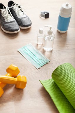 Koruyucu tıbbi maske dezenfektan jeli. Spor ayakkabıları, dambıl ve virüs ve bakterilere karşı koruyucu önlemler.