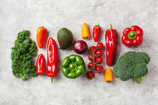 assorted red and green vegetables tomatoes, bell peppers, kale avocado