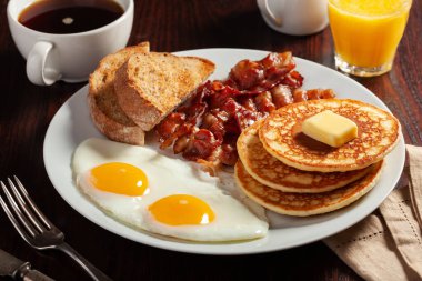 Geleneksel Amerikan kahvaltı yumurtaları pastırmalı krep ve tost.
