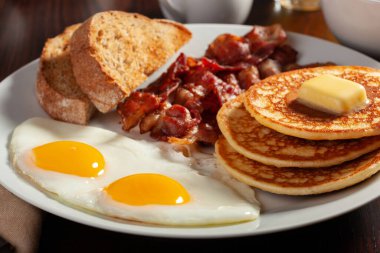 Geleneksel Amerikan kahvaltı yumurtaları pastırmalı krep ve tost.