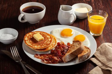 Geleneksel Amerikan kahvaltı yumurtaları pastırmalı krep ve tost.