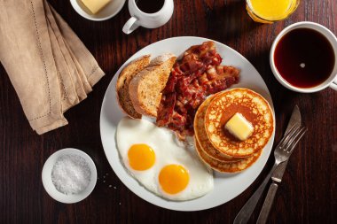Geleneksel Amerikan kahvaltı yumurtaları pastırmalı krep ve tost.