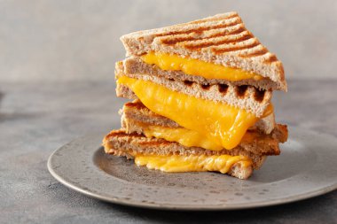 grilled cheese sandwich on gray concrete background clipart