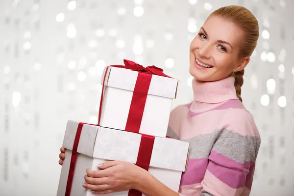 Smiling woman in cashmere sweater with gift boxes — Stock Photo, Image