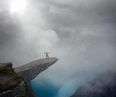 Hiker on Trolltunga with arms wide open clipart