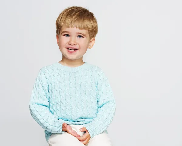 Glimlachende babyjongen in blauwe pullover — Stockfoto