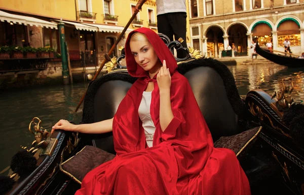 Hermosa mujer en capa roja cabalgando en góndola —  Fotos de Stock