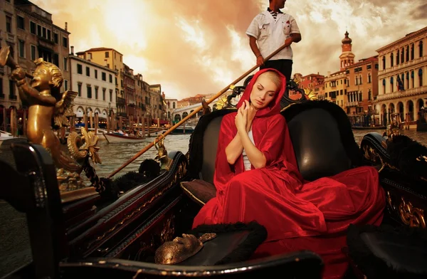 Beautiful woman in red cloak riding on gondola — Stock Photo, Image