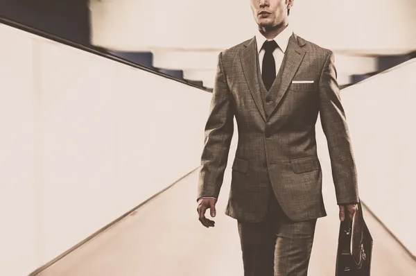 Uomo in abito classico con valigetta passeggiando per il corridoio — Foto Stock