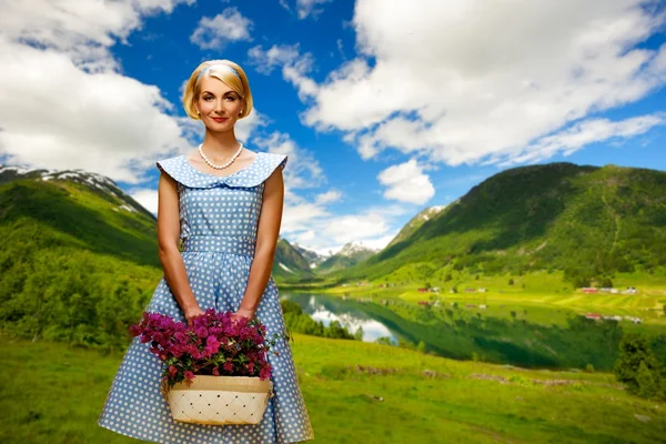 Mulher encantadora em vestido azul com flores contra vista lago — Fotografia de Stock