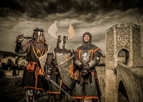 Três cavaleiros em armadura contra a ponte românica sobre o rio, Besalu — Fotografia de Stock