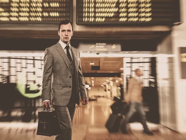 Muž v klasickém šedém obleku s Aktovkou na letišti — Stock fotografie