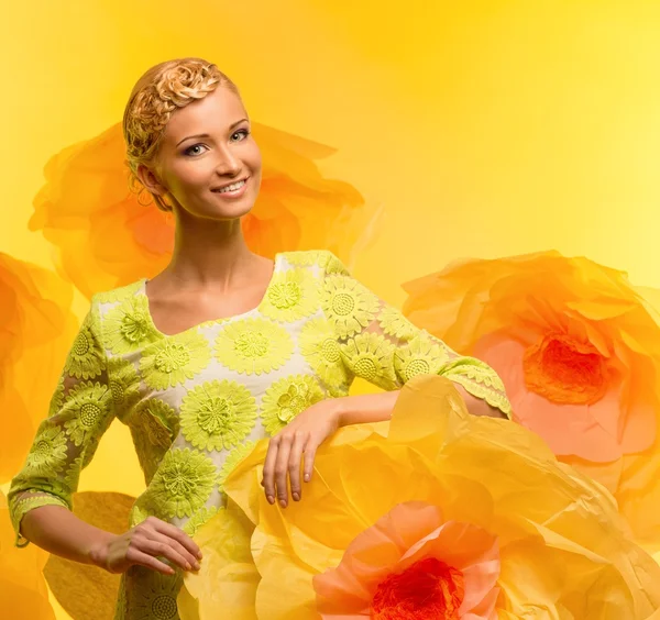 Young woman among big yellow flowers — Stock Photo, Image