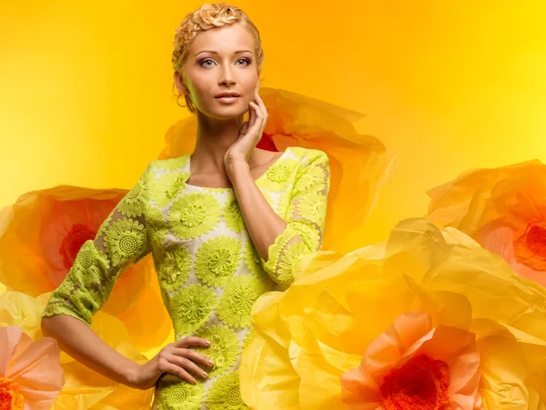 Jovem mulher entre grandes flores amarelas — Fotografia de Stock