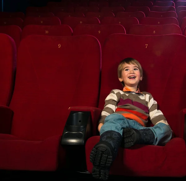 Garotinho sorridente assistindo filme em um cinema — Fotografia de Stock