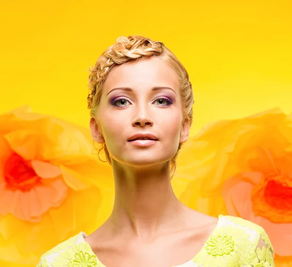 Belle jeune femme avec maquillage parmi les grandes fleurs jaunes — Photo