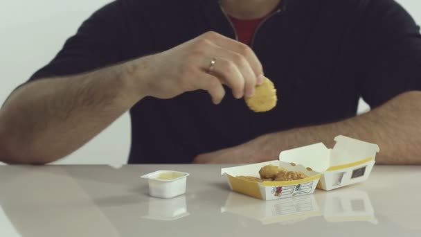 Человек ест куриные наггетсы — стоковое видео