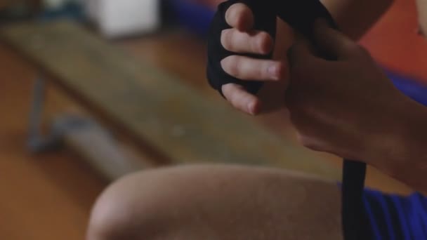 싸움을 하기 전에 그의 손에 붕대를 포장 하는 젊은 권투 선수 — 비디오