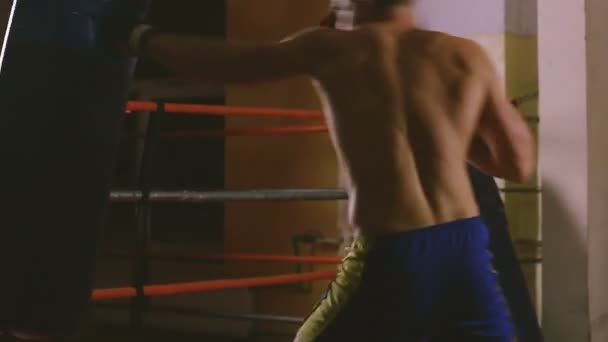 Joven boxeador entrena en saco de boxeo — Vídeos de Stock