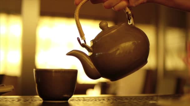 Hot water pouring from tea pot to tea cup — Stock Video