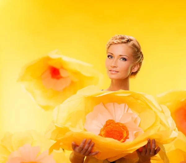 Mulher entre grandes flores amarelas — Fotografia de Stock