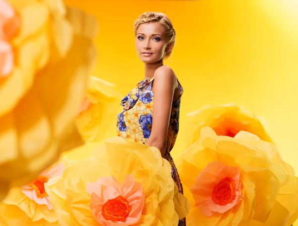 Mujer entre grandes flores amarillas —  Fotos de Stock