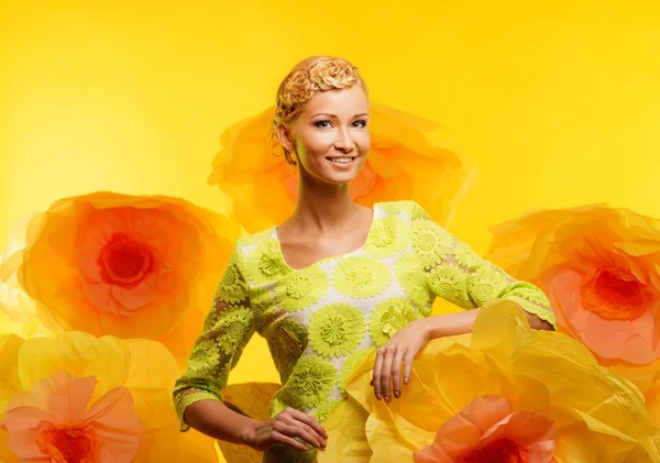 Frau zwischen großen gelben Blumen — Stockfoto