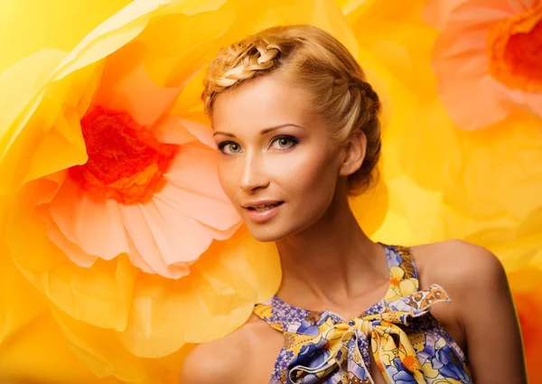 Mulher entre grandes flores amarelas — Fotografia de Stock