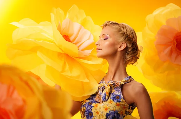 Mulher entre grandes flores amarelas — Fotografia de Stock