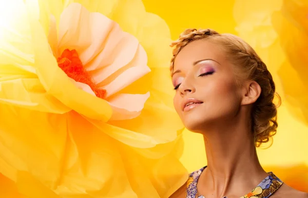 Mulher entre grandes flores amarelas — Fotografia de Stock