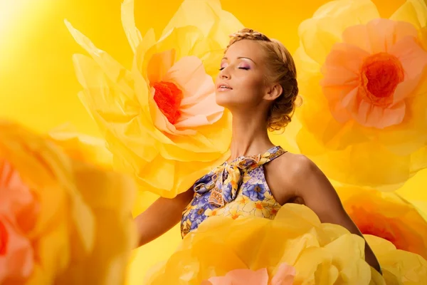 Mulher entre grandes flores amarelas — Fotografia de Stock