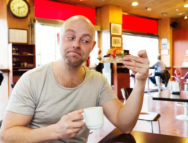カフェでのピンチョスとコーヒーを楽しむ中年の男 — ストック写真