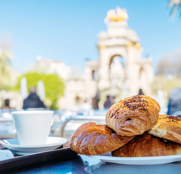 Tasty croissants with cup of coffee against famous fountain view in Barcelona — Stock Photo, Image