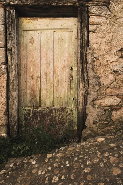 Vieille porte en bois dans mur de pierre — Photo