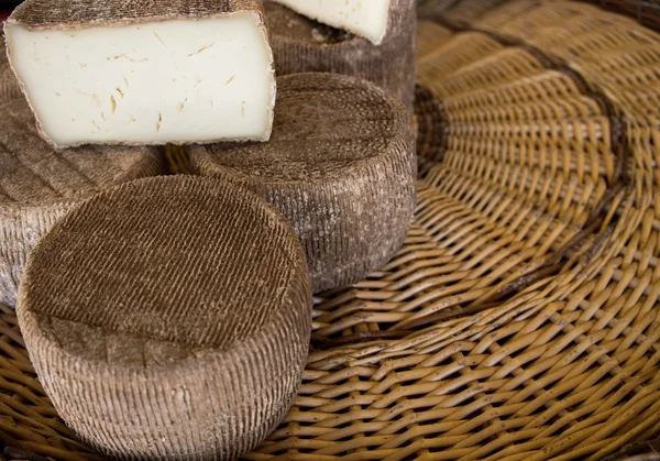 Trozos de sabroso queso en la cesta de mimbre — Foto de Stock