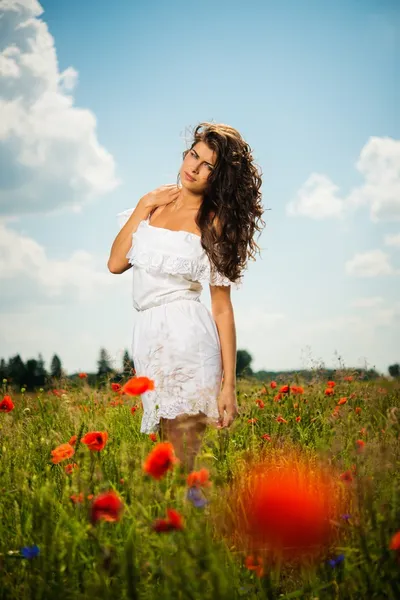 Bela jovem no campo de flores — Fotografia de Stock