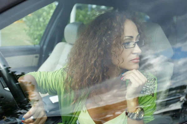 Beautiful middle-aged redhead woman behind steering wheel — Stock Photo, Image