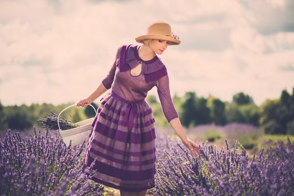 Vrouw in paarse jurk en hoed — Stockfoto