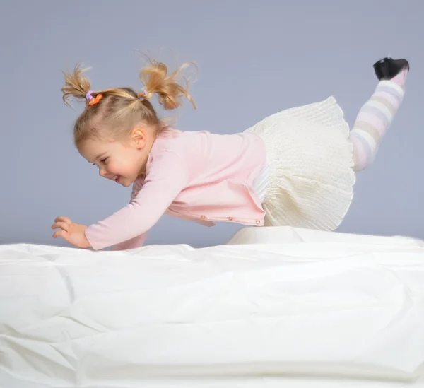 Klein meisje plezier op bed — Stockfoto