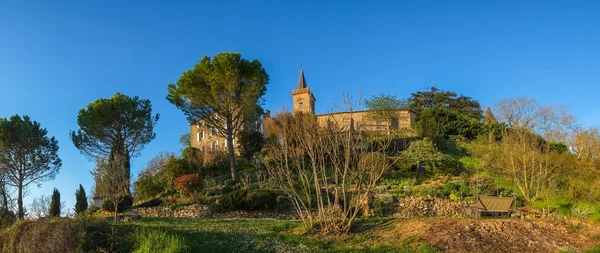 Kirchturm und Haus auf einem Gartenhügel — Stockfoto