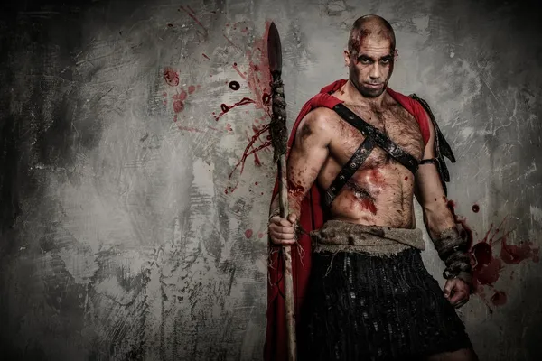 Gladiator in red coat holding spear — Stock Photo, Image