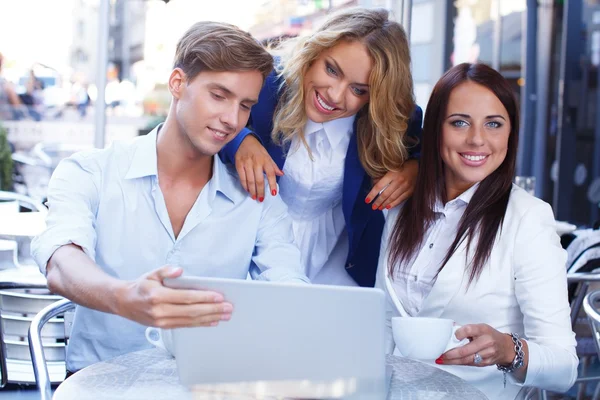 Young people with laptop in summer cafe — Stock Photo, Image