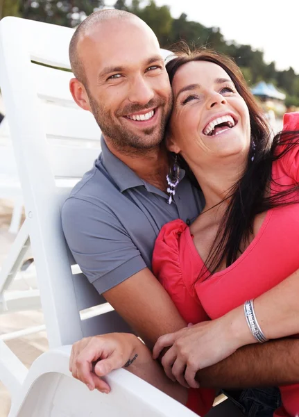 Joyeux couple souriant d'âge moyen sur une plage — Photo